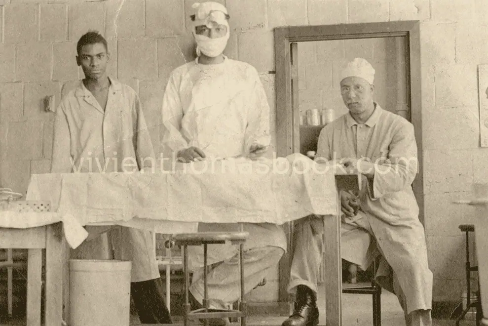 Vivien Thomas, middle, is masked and ready to operate on a lab dog in his Vanderbilt lab.